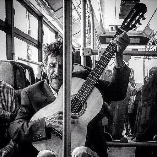 A man plays the guitar in a public bus. Tehran, Iran. Pho