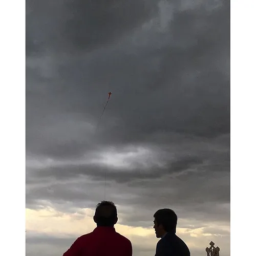 A man is flying a kite on the premises of the Milad tower