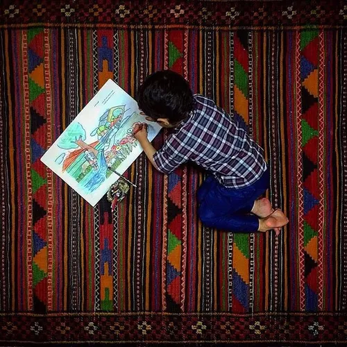 Mohammad Saleh, 4, painting at home. Ramsar, Mazandaran, 