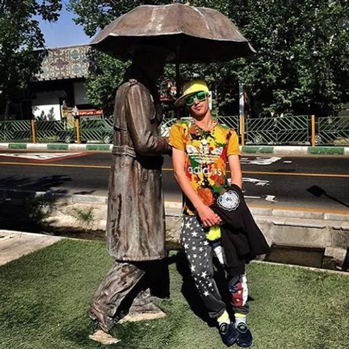 A man has his photo taken beside a statue at Melat Park. 