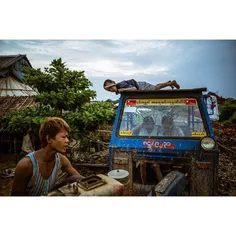 Boys play and work on a small tractor at a brick factory 