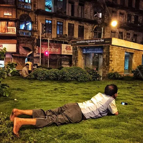 An Indian man watches music video on his mobile phone as 