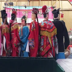 A puppeteer taking a nap behind the Chinese Puppet Opera 