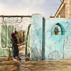 A woman washing her house’s exterior using a hose. #Neysh