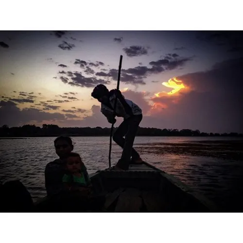 A man rows a boat on a lake in Gujarat, India. Photo by @
