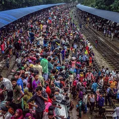 Bengali Muslims crowd on top of a train to go back to the