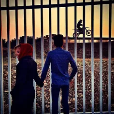 A couple watches a motocross rider training in Azadi Spor