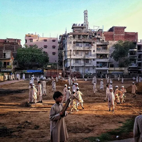 Children play on the barren ground of a neighbourhood par