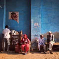 Indian people drink tea at a makeshift roadside tea stall