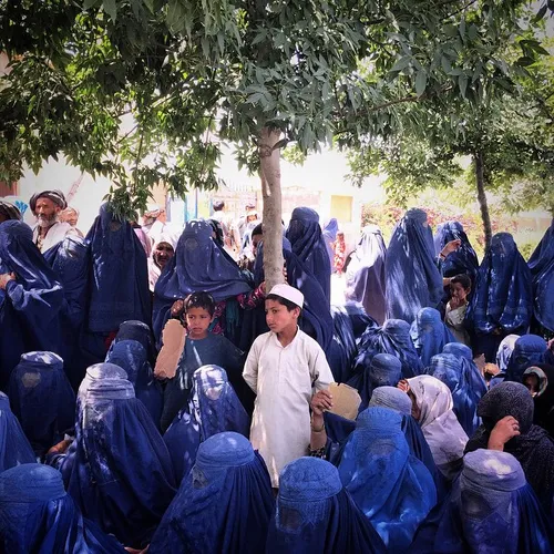 Women and children find shade in the grounds of a mosque 