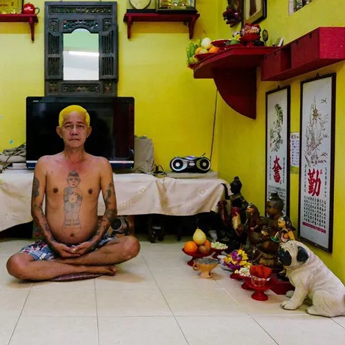 A Kumatong devotee sitting besides the altar at his home.