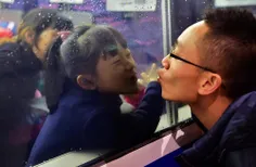 قطار در حال ترک ایستگاه شهر "فوژو " چین و پدر و دختری در 