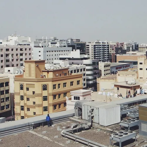 Man on a roof overlooking Deira in Dubai, UAE. Photo by S