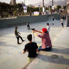 Boys take a selfie while skateboarders competing at Abo-o