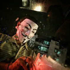 An Indian street vendor sells Vendetta mask at a traffic 