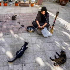 A woman smokes a hookah locally called qalyan as she clea