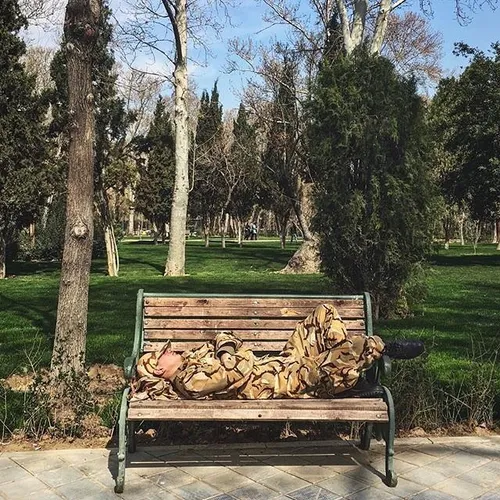 A draftee takes a nap on a bench in Park-e Shahr. Tehran,