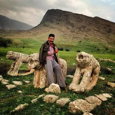 A villager leans against a stone lion, a symbolic memoria