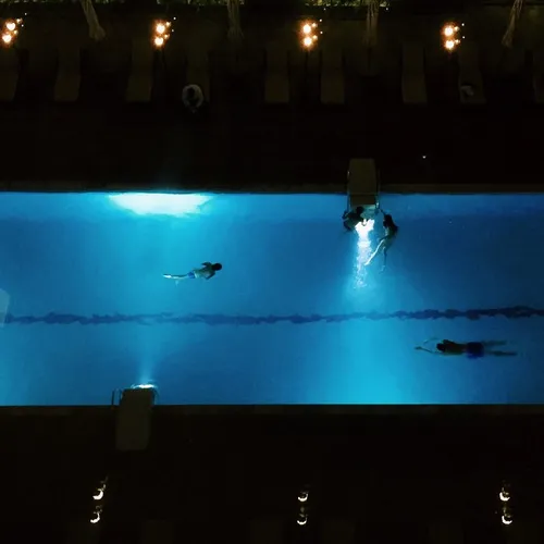 Hotel guests swimming at night, Dubai, UAE, 2015. iPhone 