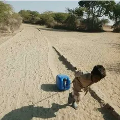 کودکی در دشتیاری درحال کشیدن آب بیست لیتری