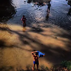 A Nepalese boy takes off his shirt while he get ready to 