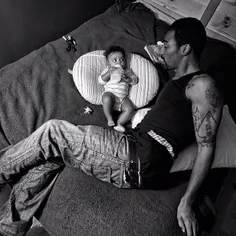 Guy Miller curls up on his bed with his youngest child, L