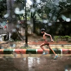 A young Indian boy runs as he tries to splash the water o
