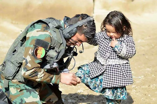 ‏دختر کوچک افغانستان دستش را به سر هموطن سربازش تکیه داده