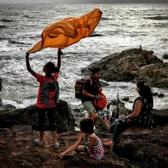 An Indian tourist plays with her stole at a cliff near th