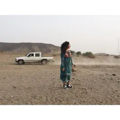 A woman in the desert attracting attention during a photo